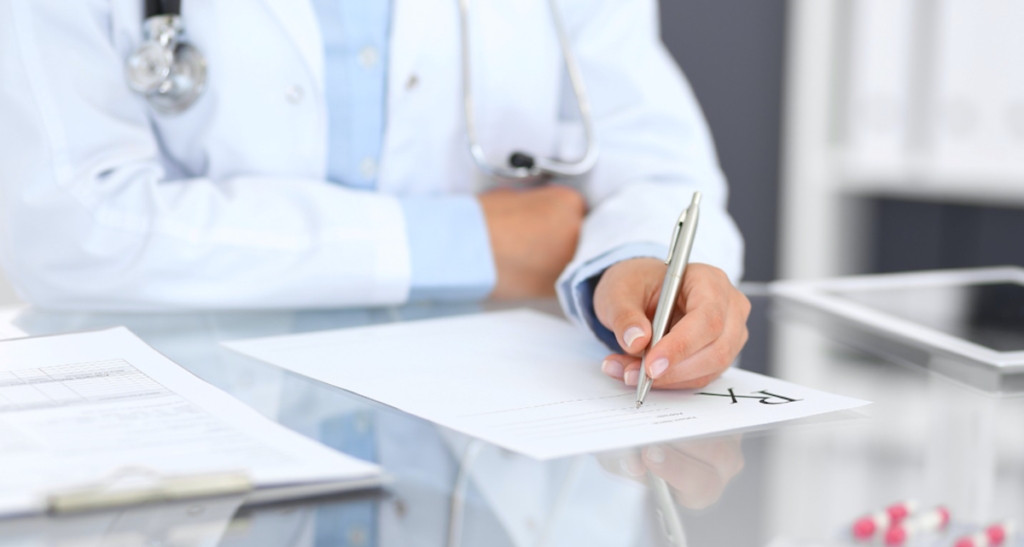 Doctor writing a prescription for a patient.