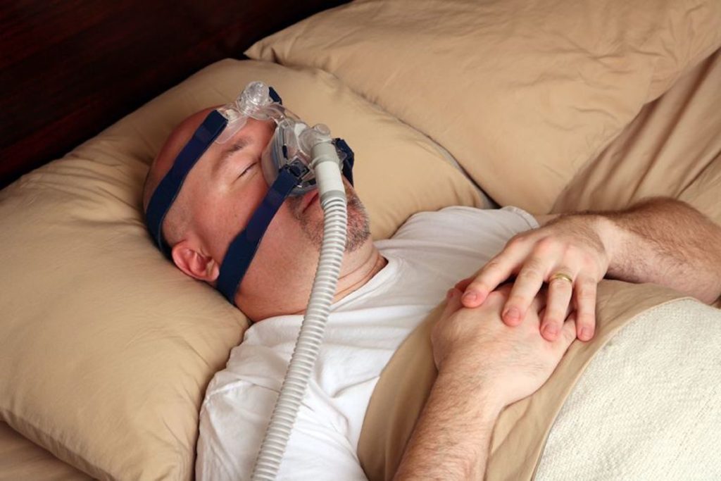 man sleeping with cpap mask